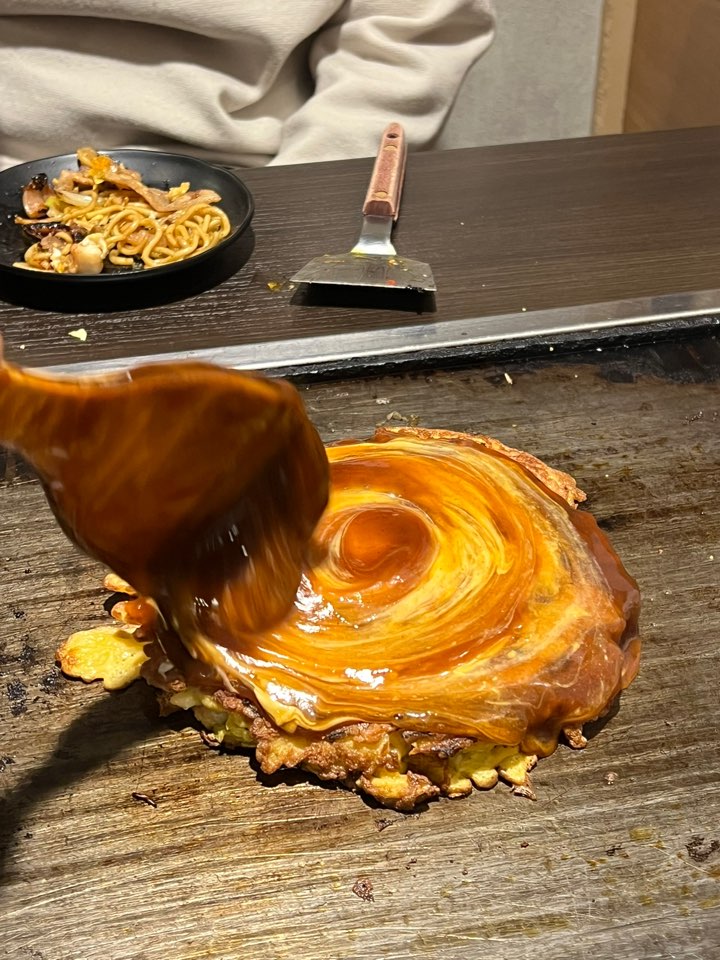 오코노미야키 위에 소스를 바르는 모습